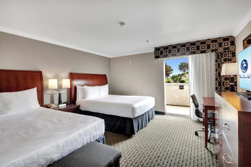 een hotelkamer met 2 bedden en een televisie bij Best Western Plus Marina Shores Hotel in Dana Point