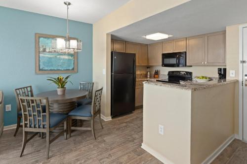 a kitchen with a table and a refrigerator at Club Wyndham Westwinds in Myrtle Beach