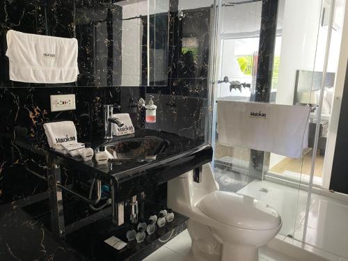a black and white bathroom with a toilet and a sink at Malokas Resort - Socorro - San Gil in Socorro