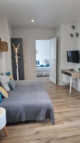 a bedroom with a bed and a desk and a television at CDG Aparts in Le Mesnil-Amelot