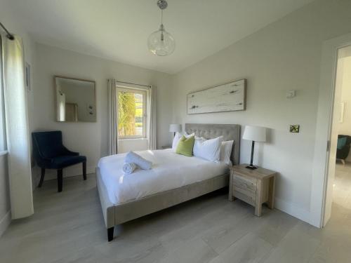 een slaapkamer met een bed, een stoel en een raam bij Kathleen's Carrowkeel Cottage in Sligo