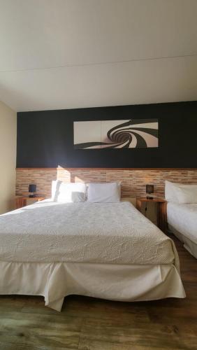 a bedroom with a large bed with a black wall at Nova Posada in Colonia del Sacramento