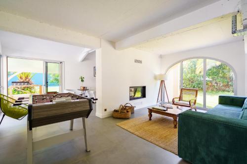 un salon avec une table et un canapé dans l'établissement Villa La Conciergerie à Biarritz, avec Fronton pour Pelote Basque, Boulodrome, Bar-Comptoir, à Biarritz