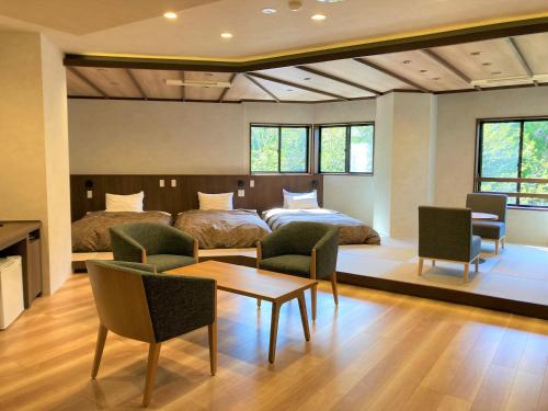 um quarto com 2 camas, uma mesa e cadeiras em 田沢湖水沢温泉郷セルリアンリゾートAoni em Senboku