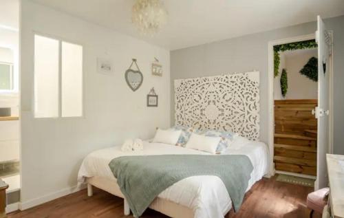 a bedroom with a large bed with white walls at Escale Caux Cooning**** Charme et Balneo Etretat in Étretat