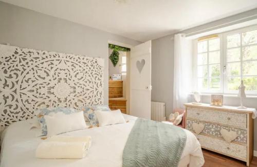 a bedroom with a large white bed with a window at Escale Caux Cooning**** Charme et Balneo Etretat in Étretat