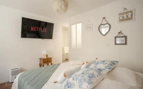 a bedroom with a bed with a tv on the wall at Escale Caux Cooning**** Charme et Balneo Etretat in Étretat