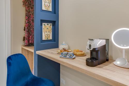 a room with a counter with a coffee maker and a blue chair at !!! IDROMASSAGGIO !!! - Love Suite in Sciacca