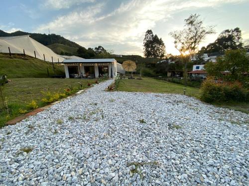 une allée en gravier avec un bâtiment et une tente dans l'établissement Casa campestre descanso relajación jacuzzi BBQ amplias zonas verdes, à Carmen de Viboral