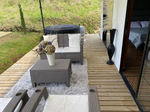 a patio with a couch and a table with flowers at Casa campestre descanso relajación jacuzzi BBQ amplias zonas verdes in Carmen de Viboral