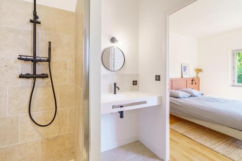 1 cama y baño con ducha y lavabo. en La Conciergerie Biarritz, en Biarritz