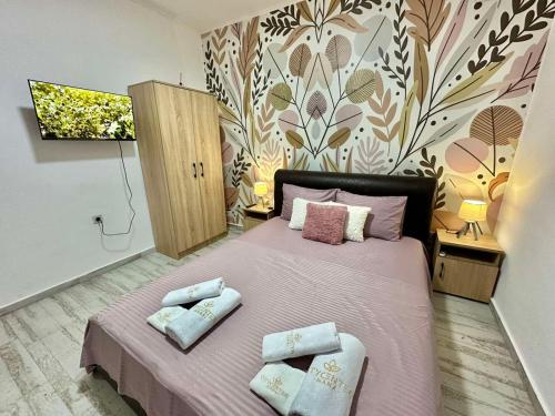 a bedroom with a pink bed with two pillows on it at City center in Ulcinj