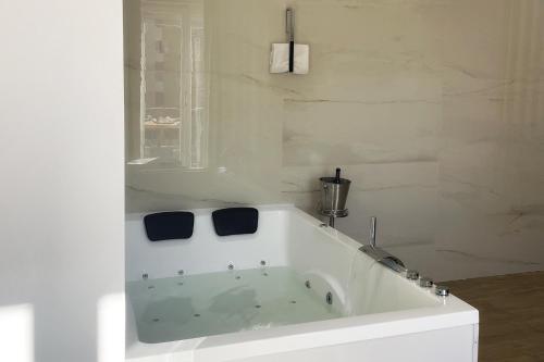 een badkamer met een wit bad en een raam bij Luxury - 5 Stars - Suite 70's rooms in Trapani