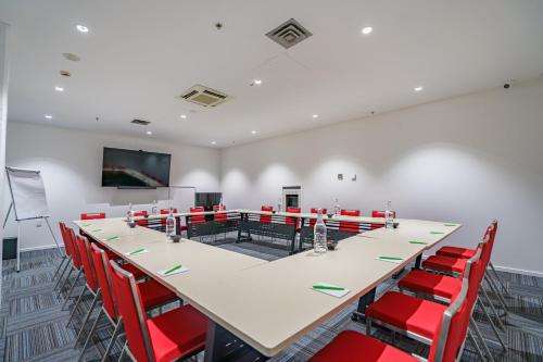a conference room with a long table and red chairs at Ibis Styles Invercargill in Invercargill