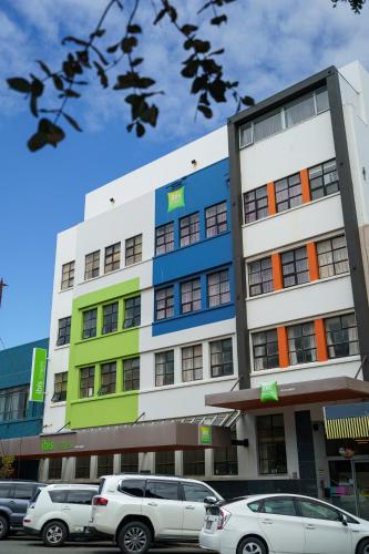 a building with cars parked in front of it at Ibis Styles Invercargill in Invercargill
