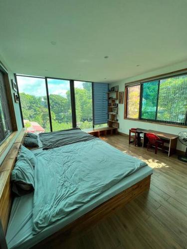 a large bed in a room with large windows at Hoà Hoa villa Ninh binh in Ninh Binh