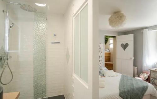 a bedroom with a bed and a glass shower at Escale Caux Cooning**** Charme et Balneo Etretat in Étretat