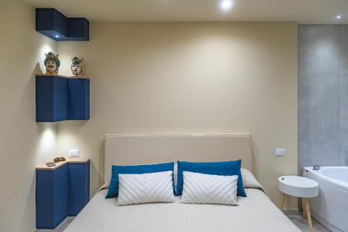 a bedroom with a bed with blue accents and a tub at !!! IDROMASSAGGIO !!! - Love Suite in Sciacca