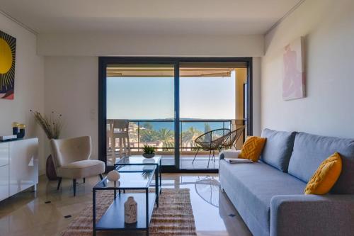 un salon avec un canapé et une vue sur l'océan dans l'établissement 1-Br apartment calm sea view pool and parking garage, à Cannes