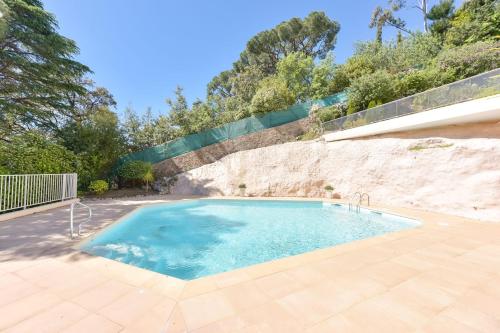- une piscine au milieu d'un patio dans l'établissement 1-Br apartment calm sea view pool and parking garage, à Cannes