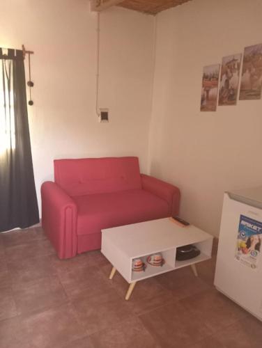 sala de estar con sofá rojo y mesa en Santa Cecilia en Cafayate
