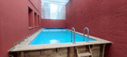 una piscina en una habitación con una pared roja en Estudio completo familiar, en La Jonquera