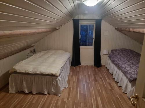 Zimmer mit 2 Betten und einem Fenster in der Unterkunft Sjarmerende hus med bade og fiskemuligheter in Flekkefjord