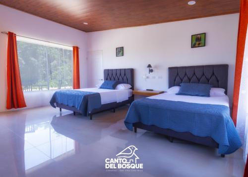 a bedroom with two beds and a window at Canto Del Bosque in San Vito