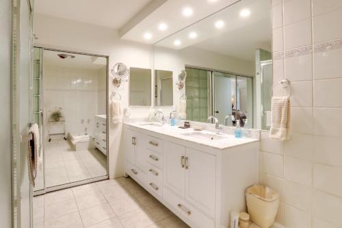 a white bathroom with a sink and a shower at Sunny Palm Springs Haven Fenced Patio, 6 Pools! in Palm Springs