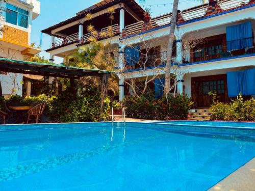 a large blue swimming pool in front of a building at Casa Terranova in Puerto Escondido