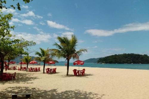 een strand met stoelen en parasols en de oceaan bij Praia da Cocanha - Caraguá SP - Área gourmet TOP in Caraguatatuba