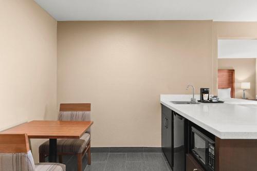 a kitchen and dining room with a table and a counter at Comfort Inn & Suites Beaverton - Portland West in Beaverton