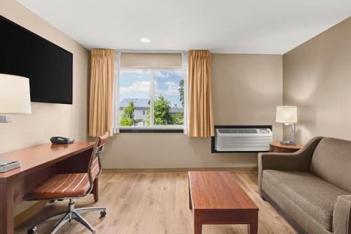a hotel room with a desk and a couch at Comfort Inn & Suites Beaverton - Portland West in Beaverton