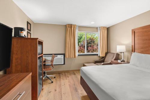 ein Hotelzimmer mit einem Bett und einem Schreibtisch in der Unterkunft Comfort Inn & Suites Beaverton - Portland West in Beaverton