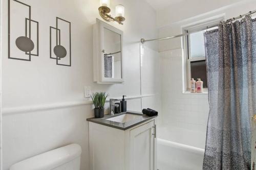 ein weißes Bad mit einem Waschbecken und einer Dusche in der Unterkunft 2BR Cozy and Furnished Apt in Hyde Park - Hyde Park 405 in Chicago