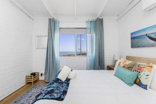 Un dormitorio con una cama grande y una ventana en OCEA84 - Quinns Beach Shack: Ocean Views, en Quinns Rocks