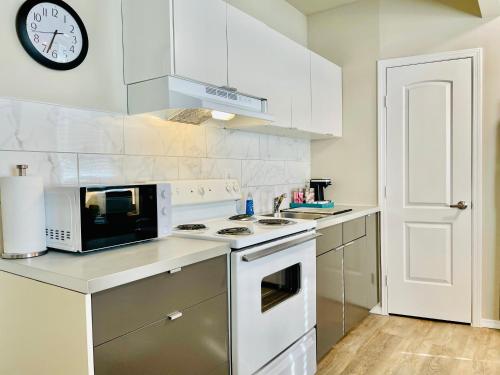 a white kitchen with a microwave and a stove at Cozy location in Midtown! in Houston