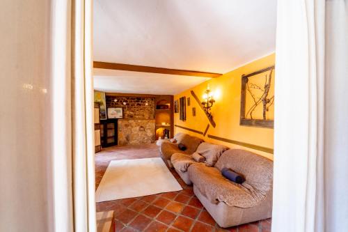 a living room with two couches and a stone wall at Hostel INpulso Atapuerca in Atapuerca
