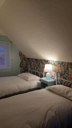 1 dormitorio con 2 camas y mesa con lámpara en Merrilees B&B, en Little Holland