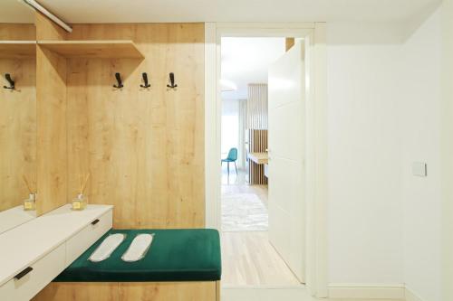 a bathroom with a white sink and a green bench at Himson Stylish Studio-Self Check-in near Airport & Mall in Iaşi