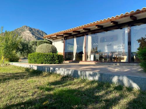 a house with a patio with mountains in the background at ENTRESIERRAS Apartamentos rurales piscina 24h con barbacoa y espacio para eventos in Cazorla