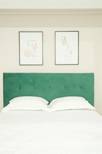 a bedroom with a white bed with three pictures on the wall at Himson Stylish Studio-Self Check-in near Airport & Mall in Iaşi