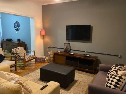 a living room with a flat screen tv on a wall at Pousada Central in Bragança Paulista