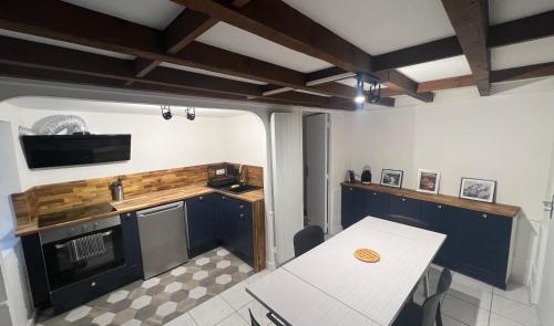 une cuisine avec une table blanche, une table et un comptoir dans l'établissement Appartement en Duplex en centre-ville de Cherbourg, à Cherbourg en Cotentin