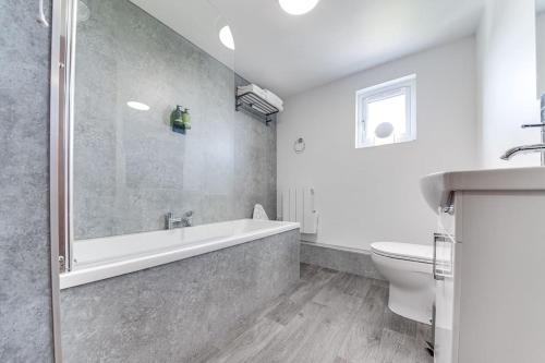 uma casa de banho com uma banheira, um WC e um lavatório. em Bijou Booth House Loft em Sheffield