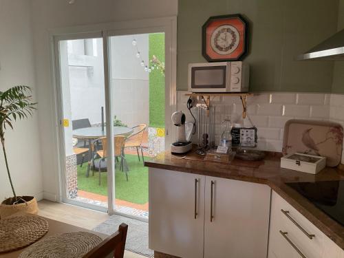 a kitchen with a table and a clock on the wall at MiraSierraHome... Tú hogar de vacaciones! in Alora