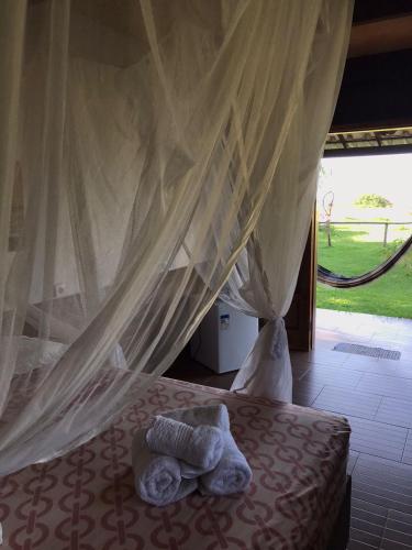 a bed with a stuffed animal laying on it at Belissima Suite frente ao mar, Praia Linda Gamboa in Cayru