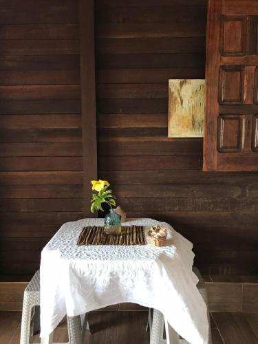 Una mesa blanca con un jarrón de flores. en Belissima Suite frente ao mar, Praia Linda Gamboa, en Cayru
