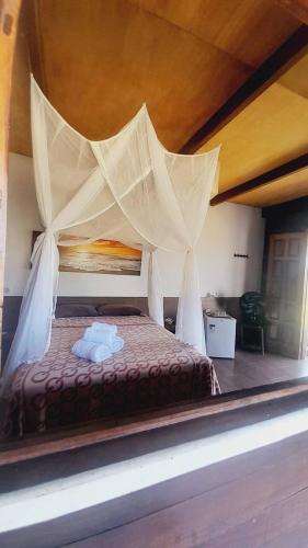 1 cama con dosel en una habitación en Belissima Suite frente ao mar, Praia Linda Gamboa, en Cayru