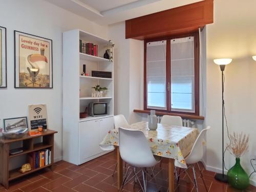 comedor con mesa, sillas y ventana en Appartamento Poli, en Castiglione dei Pepoli